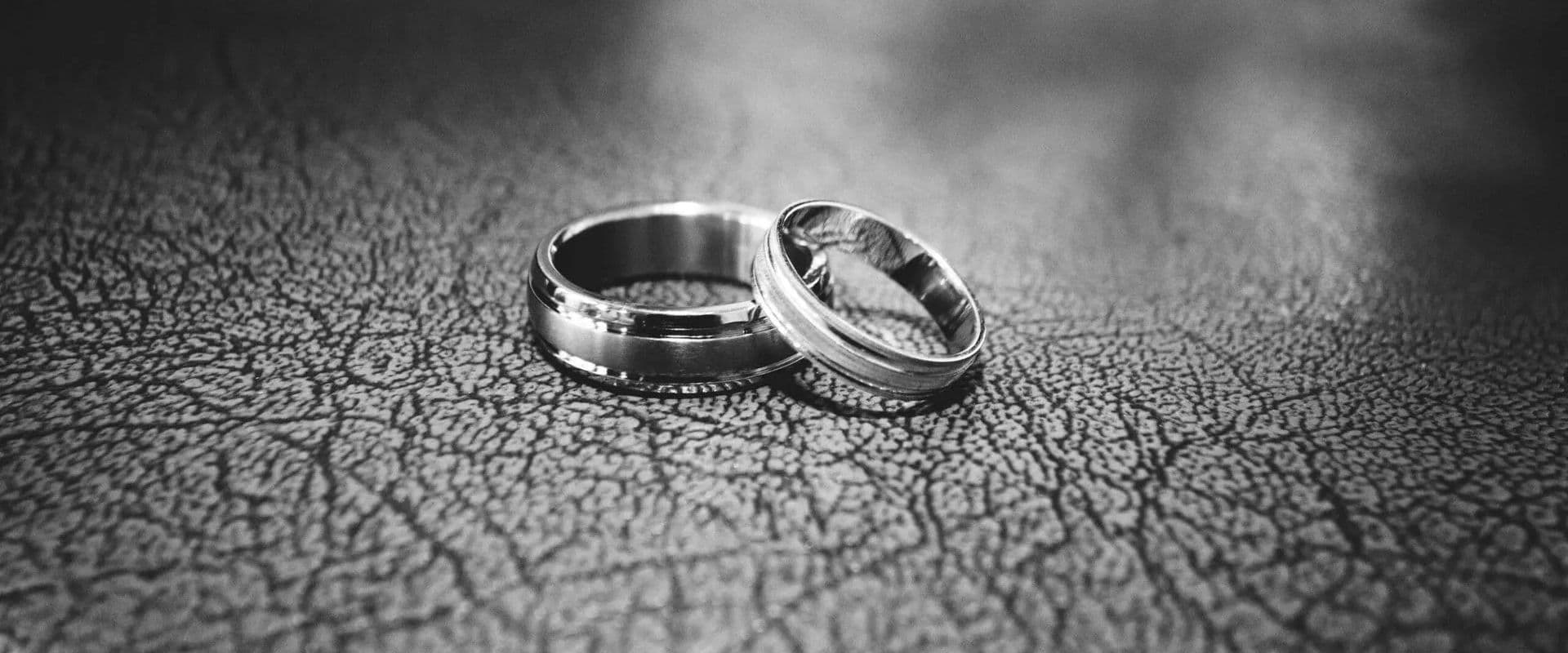 Two wedding rings resting on a textured surface.